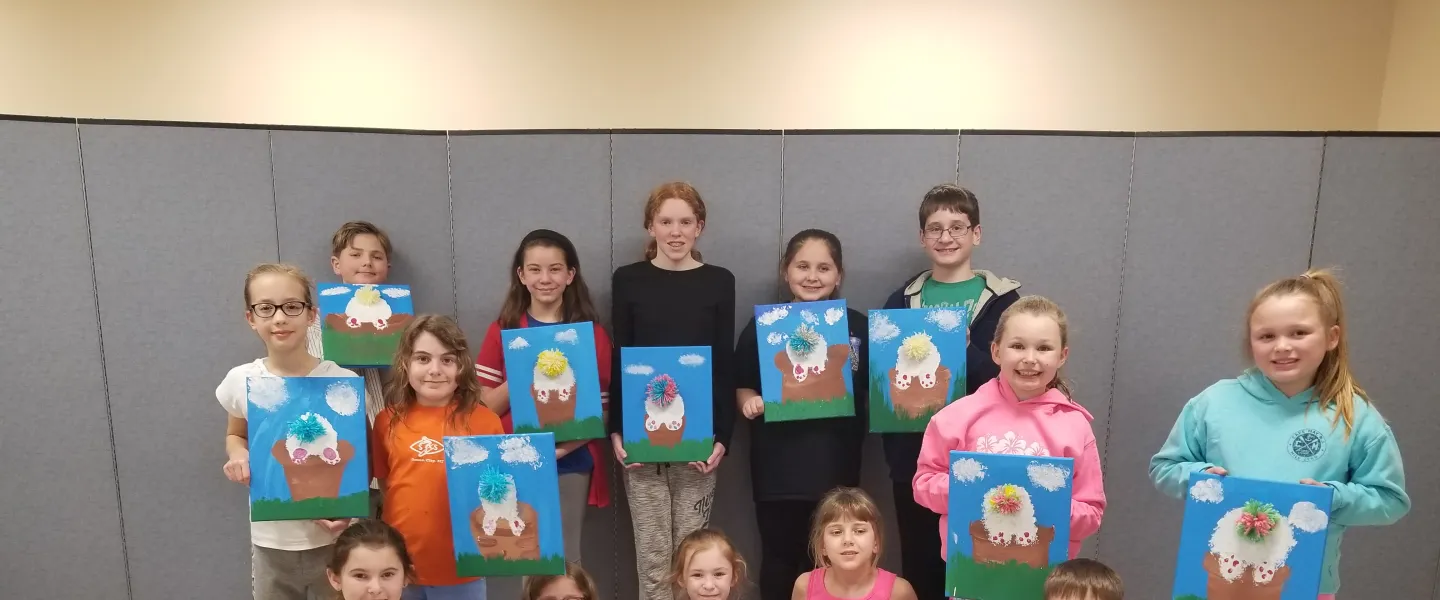 group of youth holding paintings