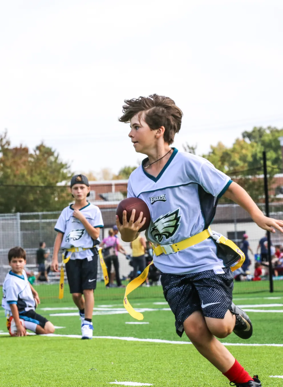 young teen playing flag football