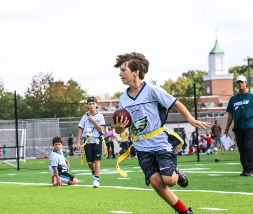 young teen playing flag football