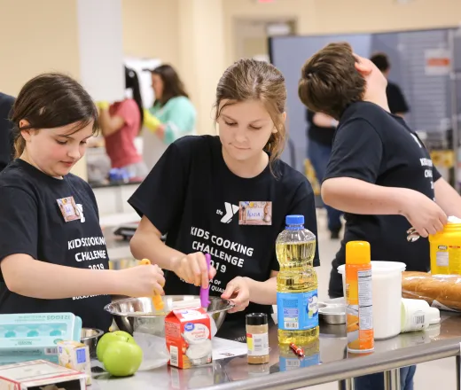 teens baking at counter while instructor looks on